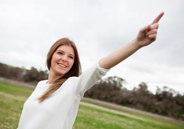 Mujer bonita indicando algo en el prado —  Fotos de Stock