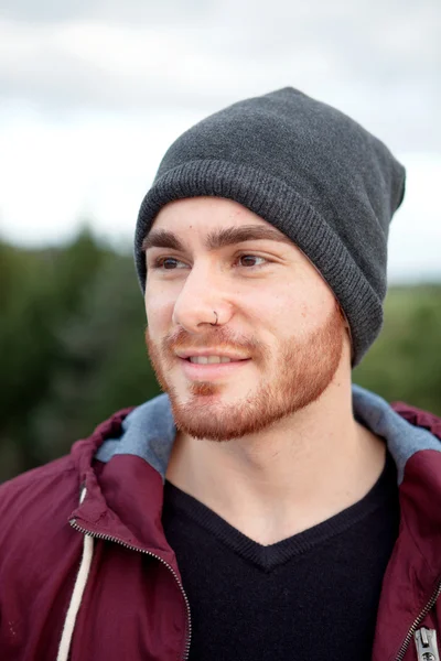 Krásný chladný muž s úsměvem a vlněné čepici — Stock fotografie
