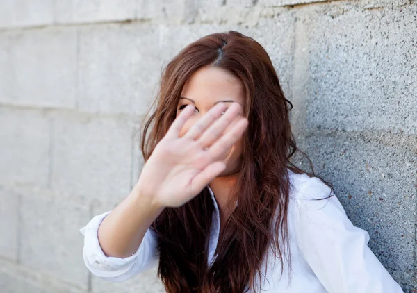 Сором'язлива брюнетка дівчина прикриває її обличчя — стокове фото