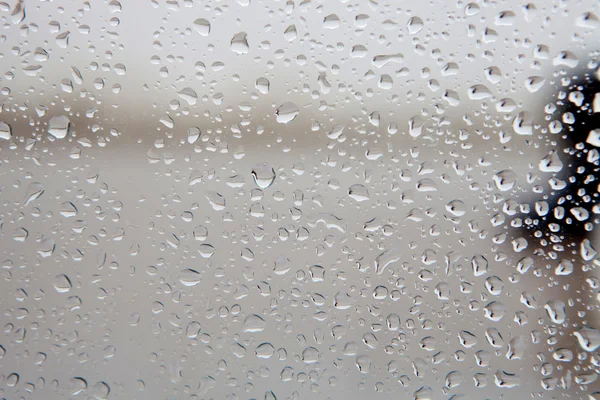 Vidro molhado com gotas de chuva cair — Fotografia de Stock