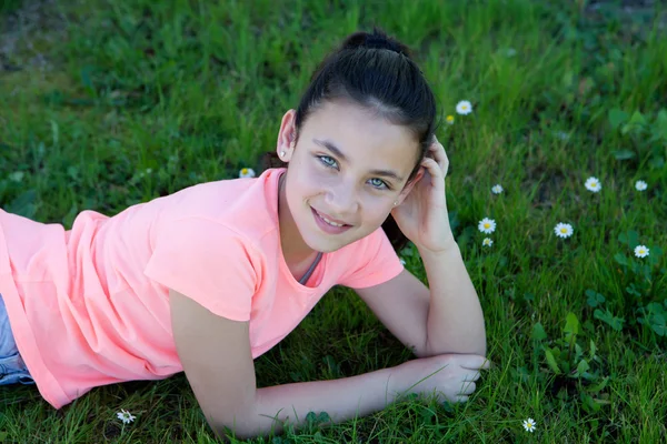 Feliz menina pré-adolescente deitada na grama — Fotografia de Stock
