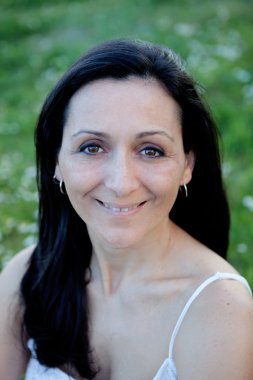 Çiçekli bir çayır üzerinde esmer kadın