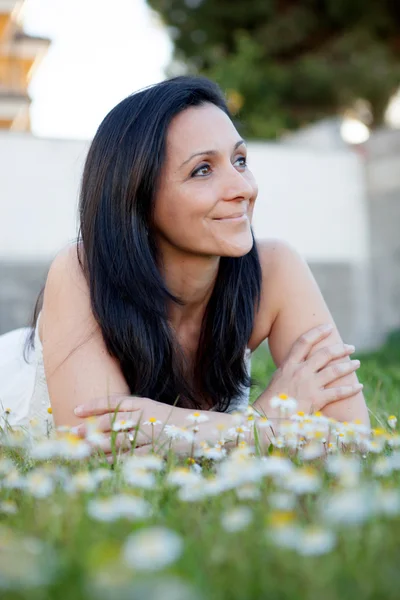 Mulher morena em um prado florido — Fotografia de Stock