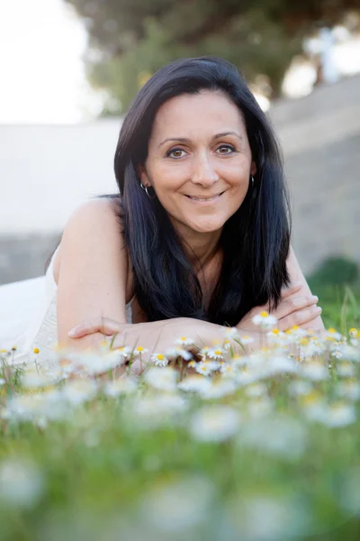 Brunette woman on a flowered meadow — Stock Photo, Image