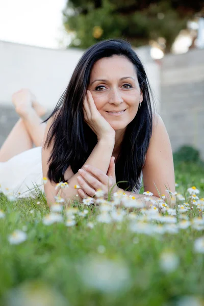 Brunette woman on a flowered meadow — Stock Photo, Image