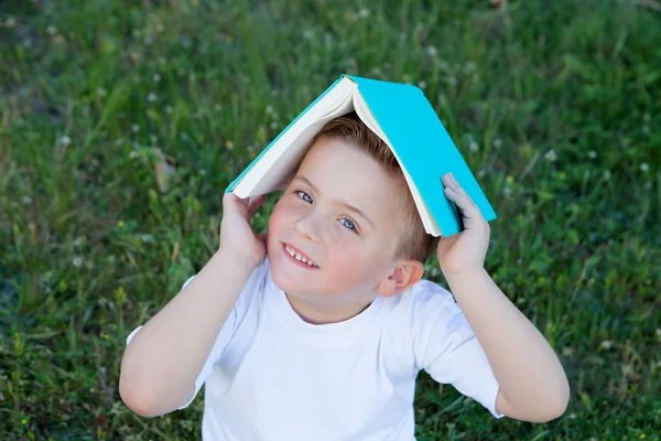 Little kid playing with a book at outside — Stock Photo, Image