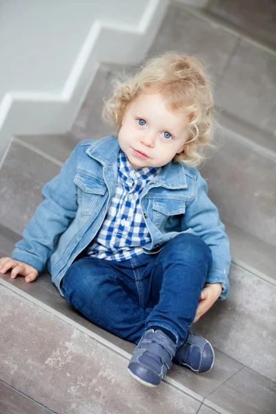 Bebé rubio sentado en las escaleras en casa — Foto de Stock