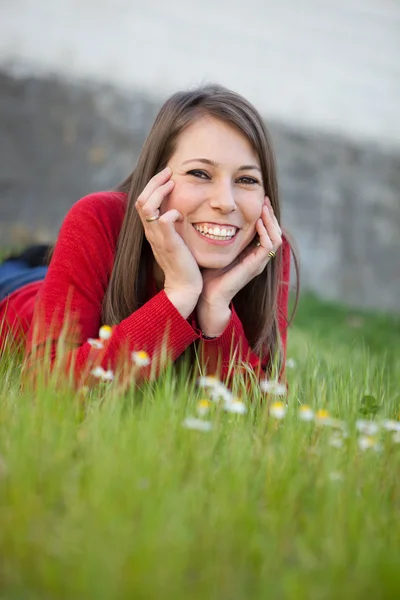 Ung kvinna liggande i gräset — Stockfoto