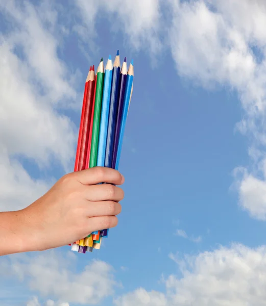 Hand holding many crayons — Stock Photo, Image