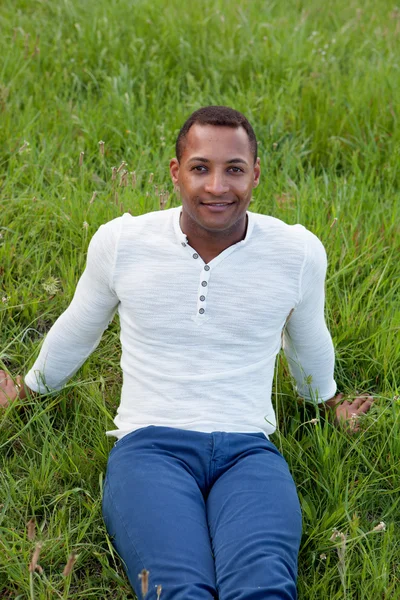 Beau mec assis sur l'herbe — Photo