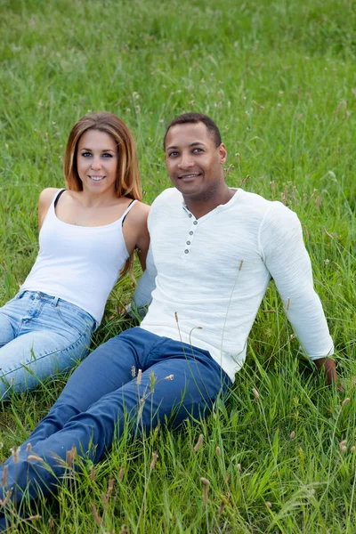 Couple couché sur l'herbe dans le champ — Photo