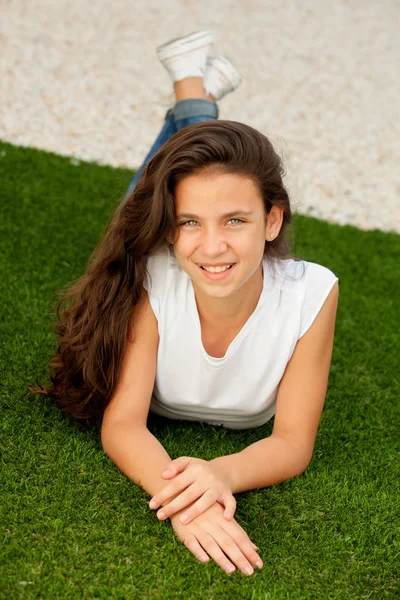 Tiener meisje liggen op het gras — Stockfoto