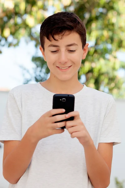 किशोर लड़का मोबाइल फोन पर देख रहा है — स्टॉक फ़ोटो, इमेज