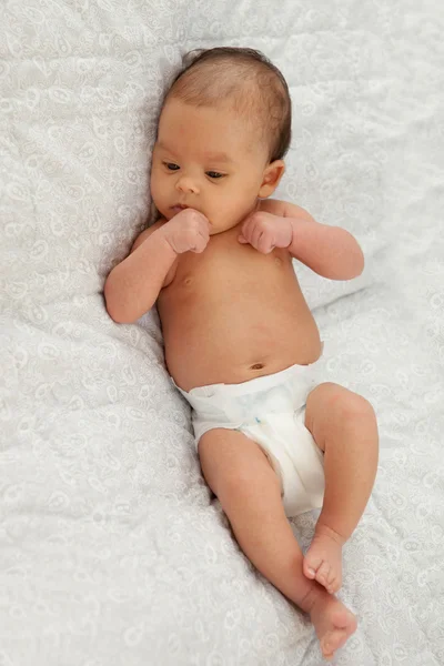 Baby in diaper lying on a white blanket — Stock Photo, Image