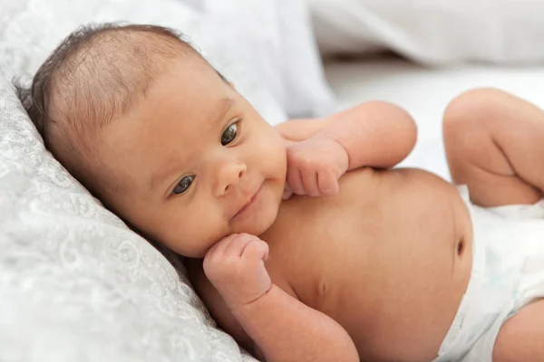 Baby in diaper lying on a white blanket — Stock Photo, Image