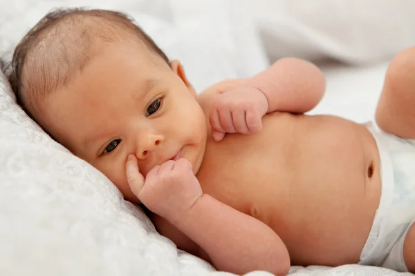 Baby in Windel auf weißer Decke liegend — Stockfoto