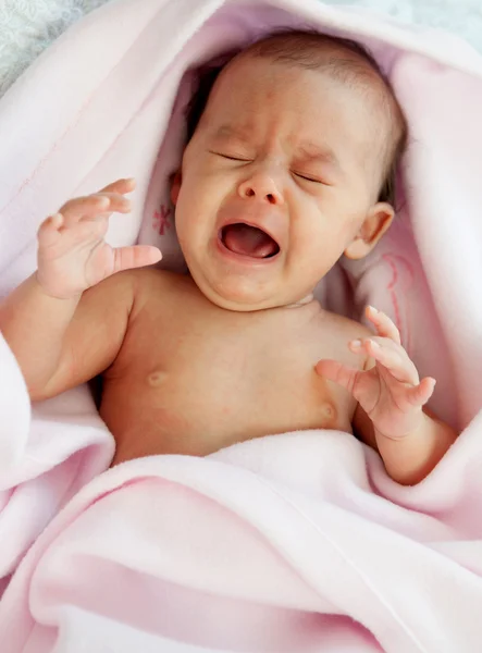 Bebê envolto em um cobertor rosa chorando — Fotografia de Stock