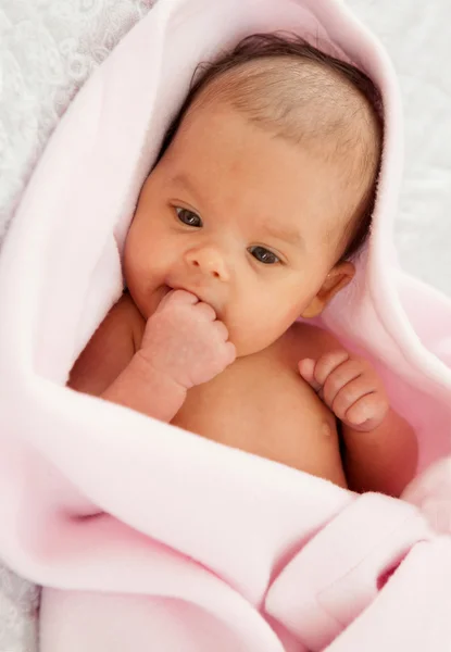 Meisje van de baby verpakt in een roze deken — Stockfoto