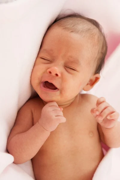 Baby wrapped in a pink blanket crying — Stock Photo, Image