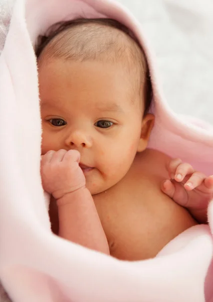 Meisje van de baby verpakt in een roze deken — Stockfoto