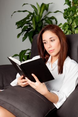genç kız evde kitap okurken