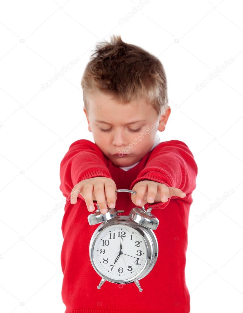 Angry little boy holding a clock  