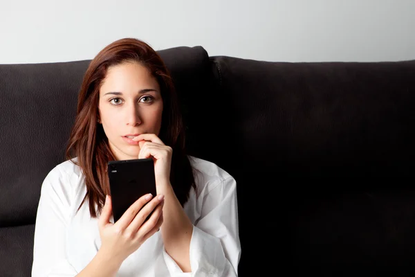 Nachdenkliche Frau schaut aufs Handy — Stockfoto