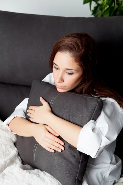 Relaxado jovem menina abraçando uma almofada — Fotografia de Stock