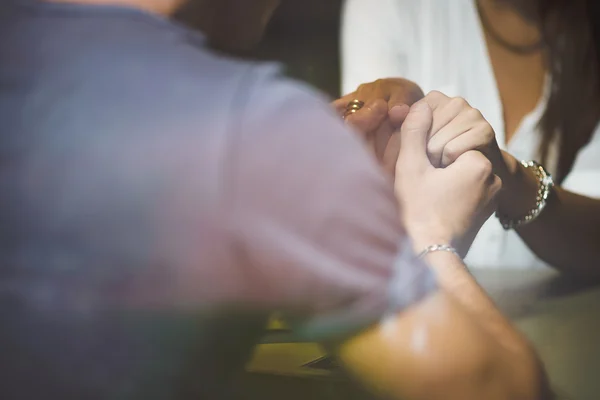 Young couple holding hands in cafe — Stock Photo, Image