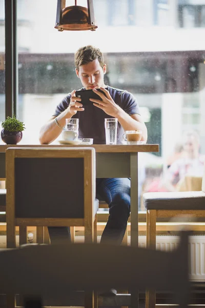 Νεαρός άνδρας, βλέποντας το δισκίο στο café — Φωτογραφία Αρχείου