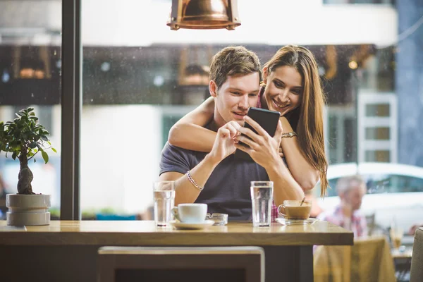 Joven pareja buscando tableta — Foto de Stock