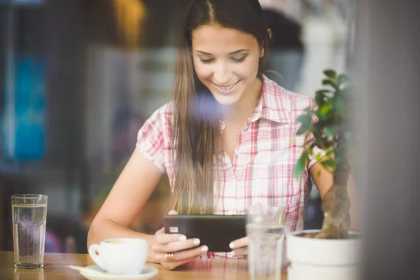 Giovane donna in caffè in cerca di tablet — Foto Stock