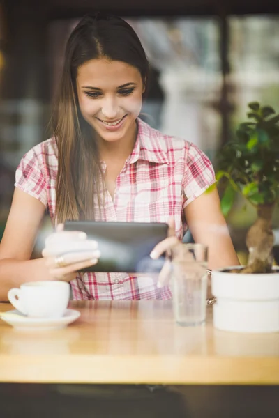 Jovem mulher no café olhando em tablet — Fotografia de Stock