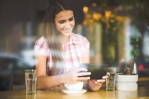 Νεαρή γυναίκα στο café ψάχνει σε δισκίο — Φωτογραφία Αρχείου