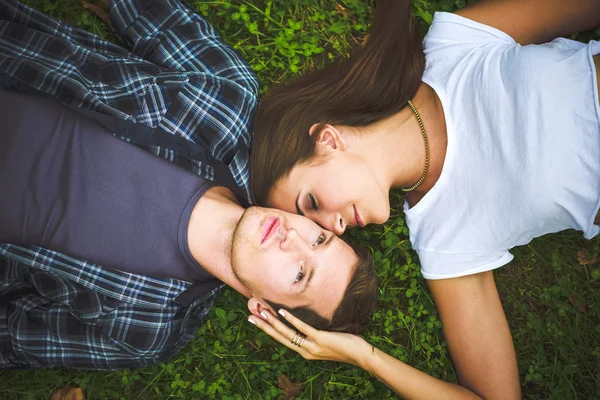 Par som ligger på gräs Stockfoto