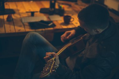 Adam evde işten sonra gitar