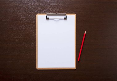 Beyaz bir kağıt ve ahşap bir arka planda kırmızı bir kalem.