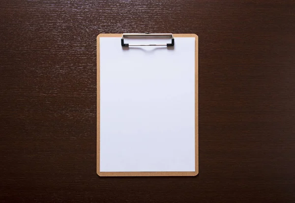 木製の背景に白い紙が置かれた木製のクリップボード — ストック写真