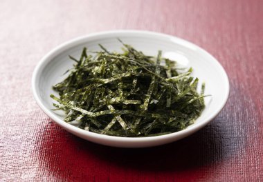 Kırmızı arka planda doğranmış yosunları kapat