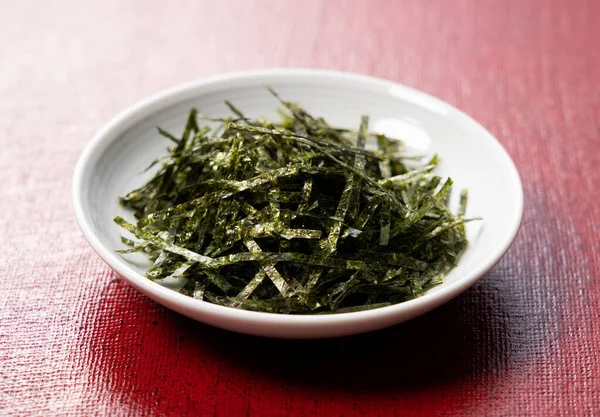 Close Chopped Seaweed Red Background — 스톡 사진