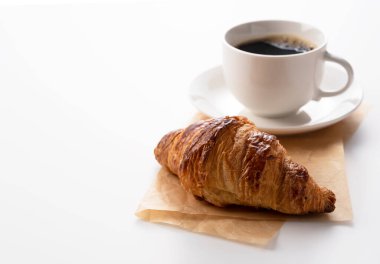 Beyaz arka planda kruvasan ve sıcak kahve.