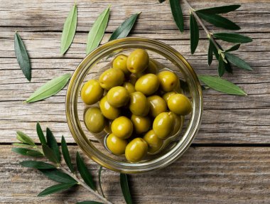 Eski ahşap kaplamalı arka planda tuzlu zeytin dalları. Yukarıdan bir manzara