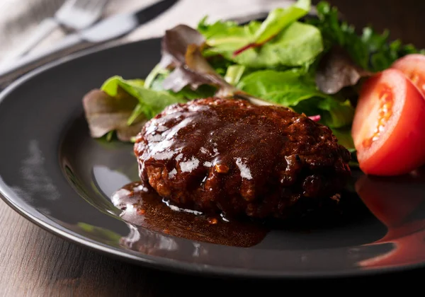 Masaya konmuş bir tabakta servis edilen yarı buzlu soslu hamburger.