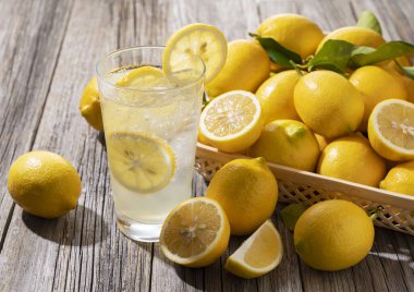 Tahta bir arka planda sepetin içinde bir sürü limon ve limon.