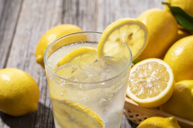 Tahta bir arka planda sepetin içinde bir sürü limon ve limon.