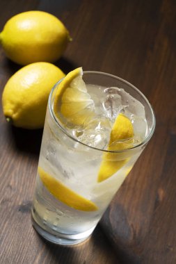Koyu ahşap arka planda, cam sette limon ekşisi. Limon kokteyli görüntüsü