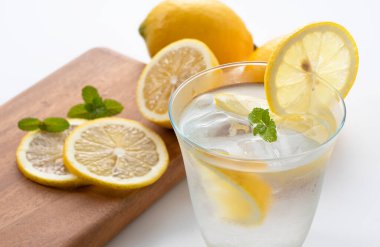 Arkasında limonlar olan soğuk bir limonata.