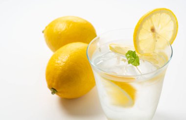 Arkasında limonlar olan soğuk bir limonata.