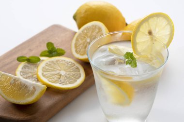 Arkasında limonlar olan soğuk bir limonata.