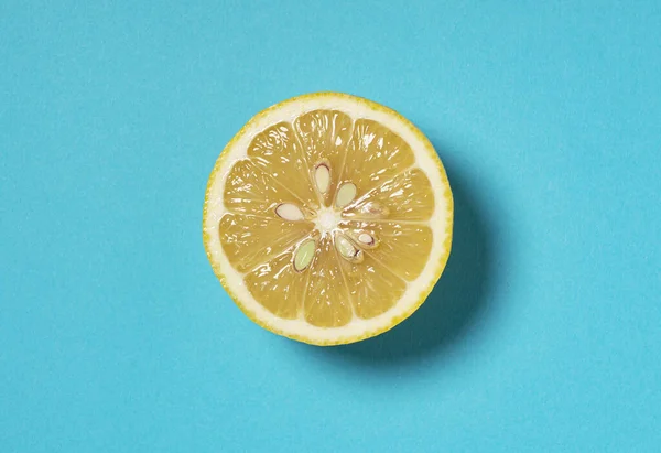 Lemons cut in half, placed on a blue background. View from directly above